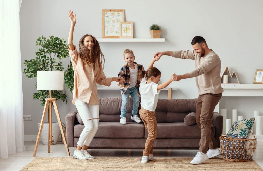 Young family dancing on the couch.